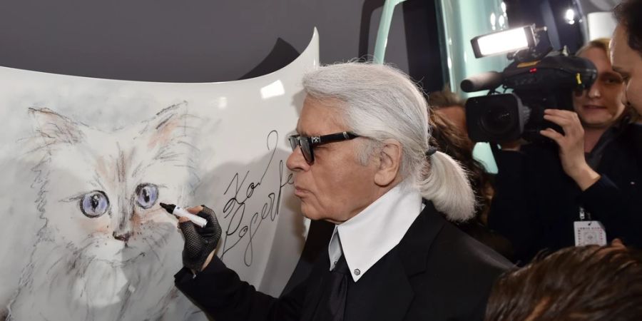 Karl Lagerfeld unterschreibt ein Bild seiner Katze Choupette.