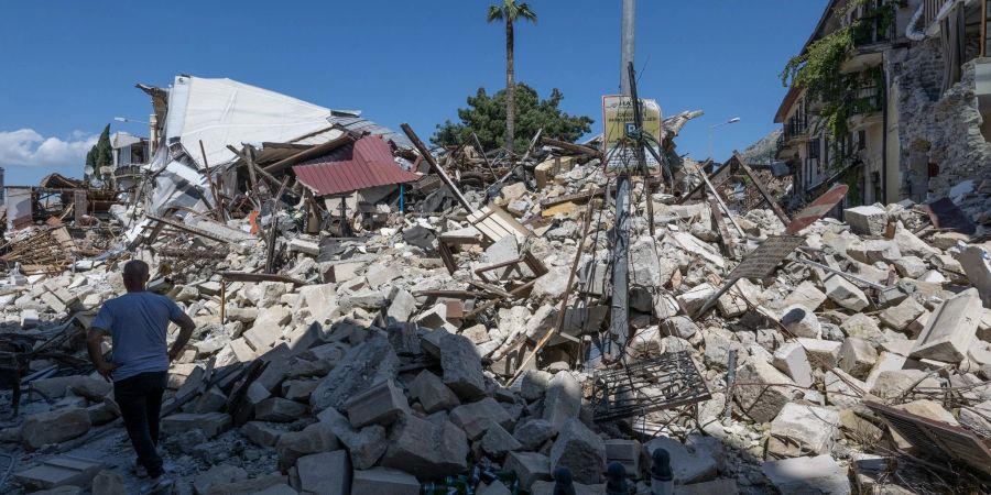 Ein Mann geht in der Altstadt von Antakya an den Trümmern eingestürzter Wohnhäuser durch das Erdbeben vorbei.