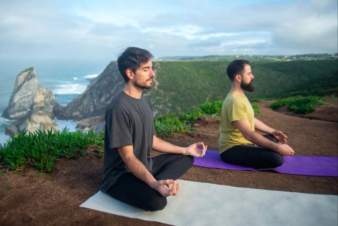 Das wichtigste bei der Yoga-Bekleidung: Sie müssen sich darin wohlfühlen und sich gut bewegen können. Zwei Männer meditieren