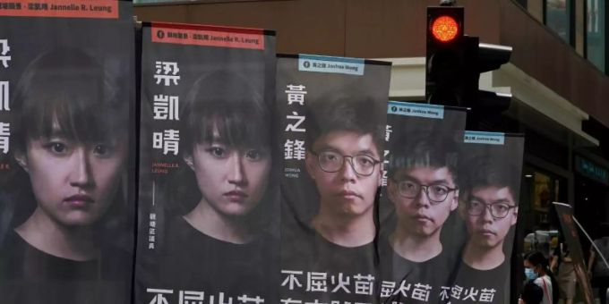 Der prominente Aktivist Joshua Wong (auf den hinteren drei Bannern zu sehen) sitzt wegen des Vorwurfs der illegalen Organisation eines Protests im Gefängnis. joshua wong