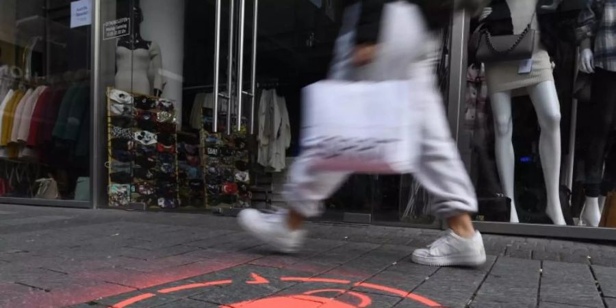 Masken-Symbol in einer Kölner Einkaufsstrasse. Corona und der für den November verhängte Teil-Lockdown sorgen ausgerechnet im wichtigen Weihnachtsgeschäft für leere Innenstädte. Foto: Roberto Pfeil/dpa