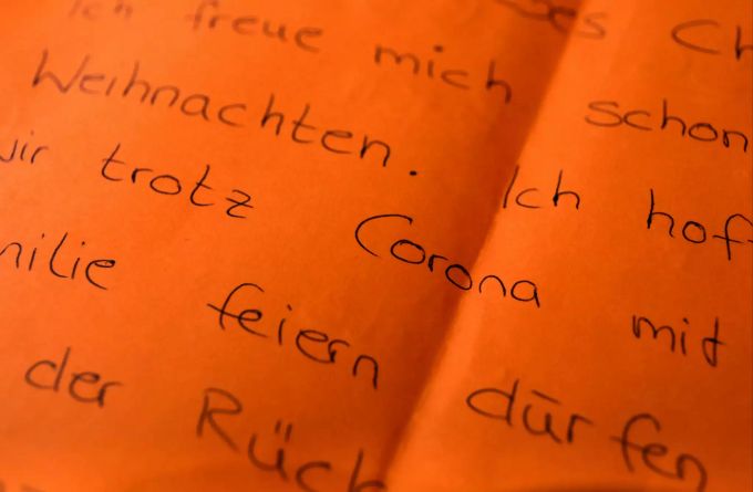 Der Brief eines Kindes, in dem es sich wünscht, trotz Corona mit der Familie Weihnachten zu feiern, liegt auf einem Tisch in der Weihnachtspostfiliale. Foto: Oliver Berg Kinderwünsche zu Weihnachten