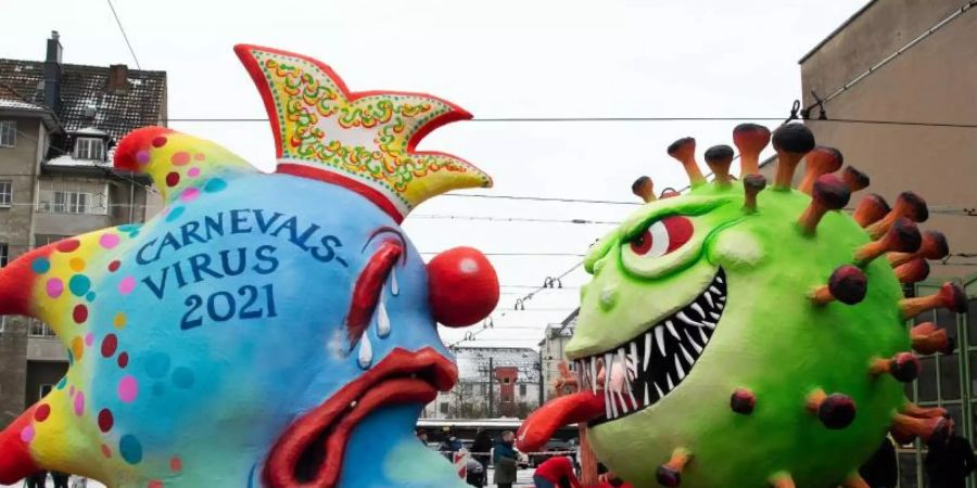 Coronavirus vs. Carnevalsvirus auf einem Mottowagen in Düsseldorf. Foto: Federico Gambarini/dpa