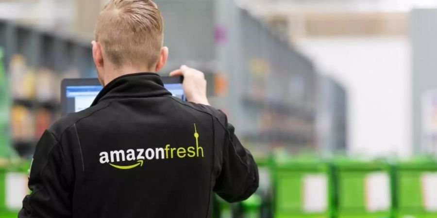 Ein Mitarbeiter des Lebensmittellieferdienstes Amazon Fresh steht in einem Depot der Firma. Foto: Monika Skolimowska/dpa