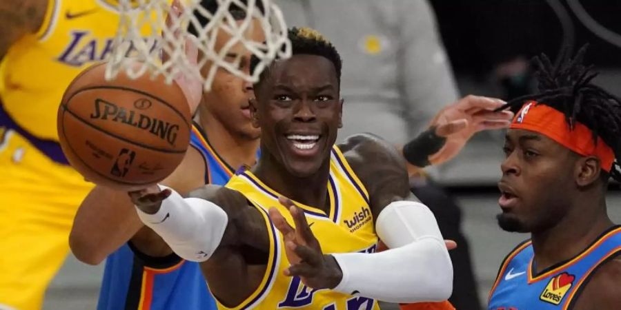 Lakers-Spieler Dennis Schröder (M/am Ball) kann sich am Korb gegen Luguentz Dort(r) von Oklahoma City Thunder durchsetzen. Foto: Mark J. Terrill/AP/dpa