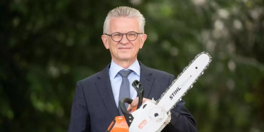 Bertram Kandziora, Vorstandsvorsitzender der Stihl AG, posiert mit einer akkubetriebenen Motorsäge. Foto: Marijan Murat/dpa