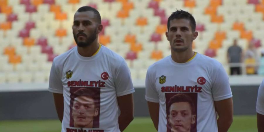 Zwei Spieler des türkischen Erstligisten Yeni Malatyaspor tragen ein T-Shirt mit der Aufschrift «Wir sind bei dir. Nein zu Rassismus». Ein Foto von Mesut Özil ist aufgedruckt.