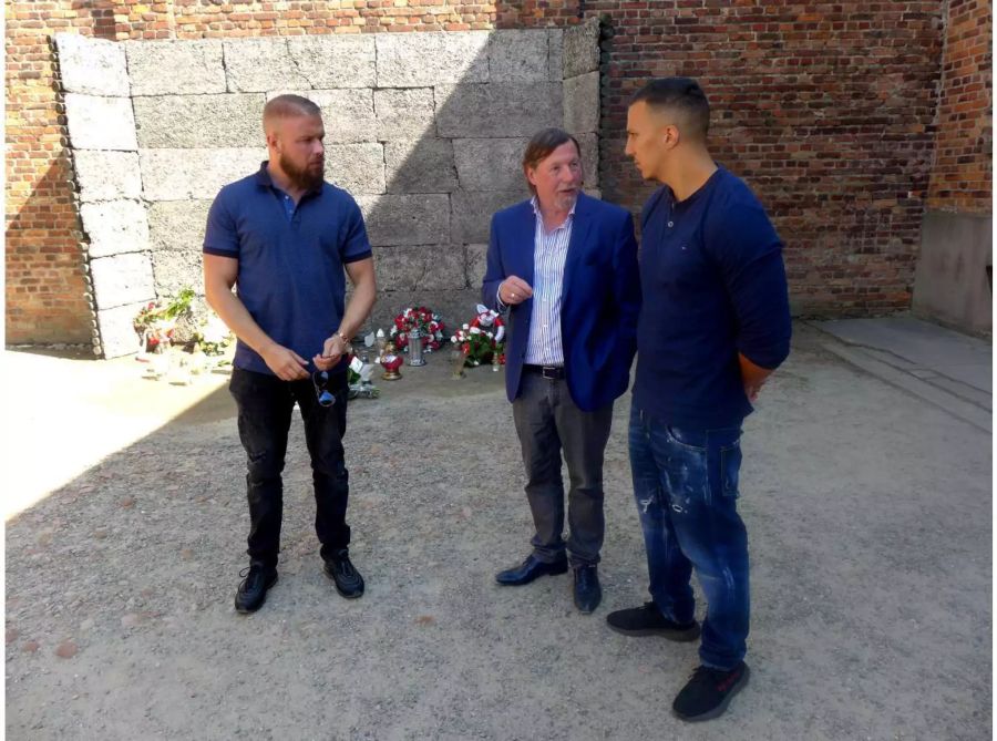 Der Vizepräsident des Internationalen Auschwitz Komitees spricht mit den Rappern Kollegah (l) und Farid Bang nach der Niederlegung eines Blumengebindes an der Todeswand in der KZ-Gedenkstätte Auschwitz.