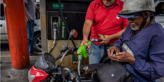 Ein Motorradfahrer tankt in Venezuela Benzin. Venezuela