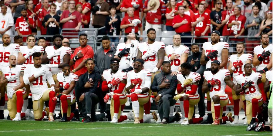 Spieler der San Francisco 49ers knien während der Nationalhymne vor einem NFL-Spiel.