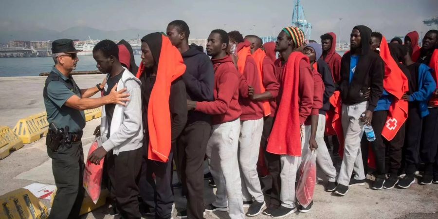 Spanien, Algeciras: Ein Beamter der spanischen Guardia Civil (l.) hält einen Flüchtling an den Schultern. Die Flüchtlinge sind vom spanischen Seerettungsdienst aus der Strasse von Gibraltar gerettet worden.