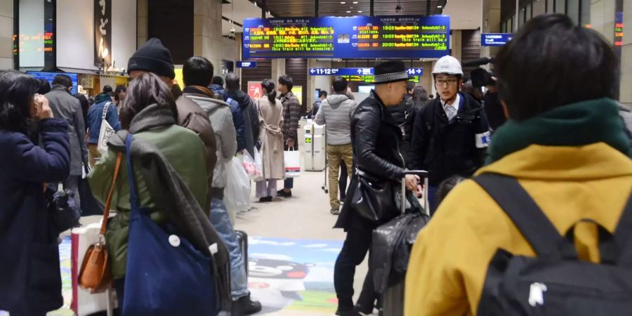 Passagiere stehen am Bahnhof Kumamoto (JPN).