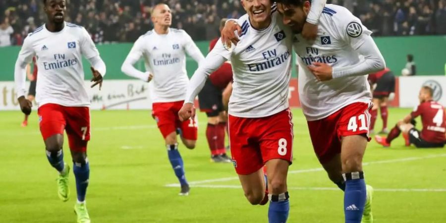 Torschütze Berkay Özcan (r/41) und Lewis Holtby (M/8) feiern das 1:0 für den HSV gegen Nürnberg. Foto: Christian Charisius