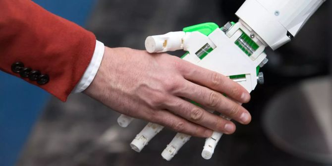 Ein humanoider Roboter gibt einem Menschen die Hand