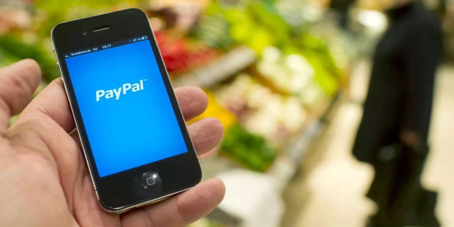 Der Startbildschirm der PayPal App ist in der Lebensmittelabteilung eines Warenhauses in Berlin auf dem Display eines Smartphones zu sehen. Kontaktloses Bezahlen an der Ladenkasse im Vorbeigehen oder mit einer App auf dem Handy - neue Bezahlverfahren sind im Kommen.