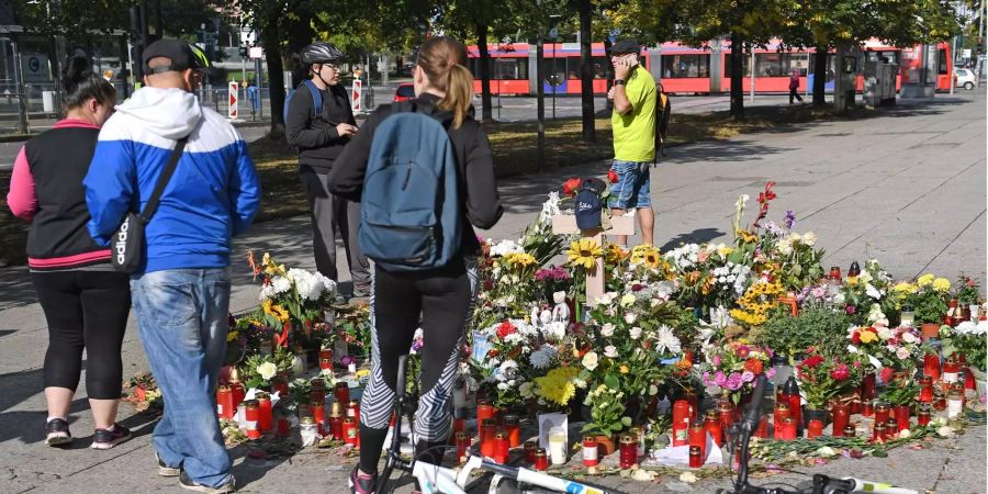 Passanten stehen im Zentrum von Chemnitz am Gedenkort für den getöteten Daniel H..