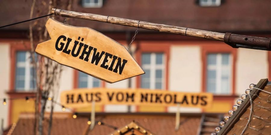 An einer Bude ist ein Schild mit der Aufschrift "Glühwein" angebracht.