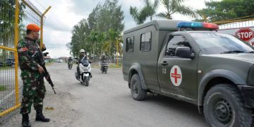 Indonesische Sicherheitskräfte bewachen einen Leichentransport.