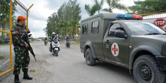 Indonesische Sicherheitskräfte bewachen einen Leichentransport eines getöteten Arbeiters. Indonesische Sicherheitskräfte bewachen einen Leichentransport.