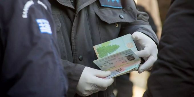 Laut der Organisation Frontex ist die Zahl der illegal einreisenden Migranten um rund ein Drittel gesunken. Griechische Beamten kontrollieren einen Ausweis.