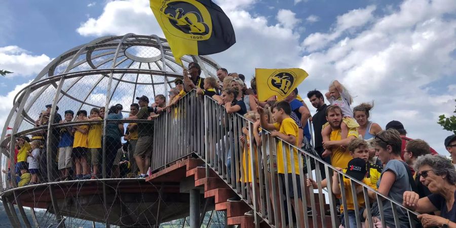 YB-Fans erwarten am Flughafen Bern-Belp ihre Mannschaft mit Fahnen und gelben YB-Shirts.