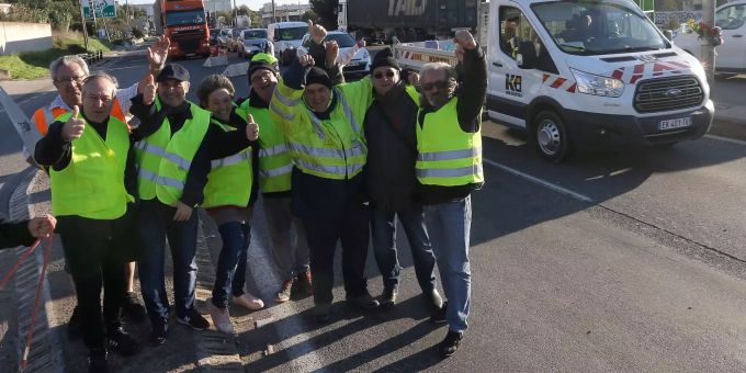Angesichts von Massenprotesten gegen die Steuererhöhungen kündigte Präsident Macron eine Kurskorrektur an. Die Kraftstoffsteuern sollten künftig an die Entwicklung des Weltmarktpreises für Öl gekoppelt werden, damit die Kosten für die Bürger nicht zu hoch steigen. Demonstranten mit gelben Westen lachen bei einem Protest gegen die Steuererhöhungen für Benzin und Diesel an einer Kreuzung.