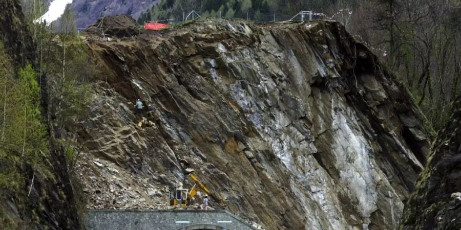 Arbeiter tragen nach einem Felssturz bei einer Felswand unterhalb von Mesocco Gestein ab.