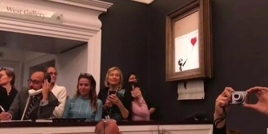 Banksy-Kunstwerk Das Videostandbild, das auf dem Instagram Account des Künstlers Banksy veröffentlicht wurde, zeigt das Werk «Girl with Balloon» von Banksy, welches kurz nach seiner Versteigerung beim Auktionshaus Sotheby's geschreddert wird.