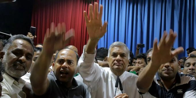Die Verfassungskrise in Sri Lanka hält an. Ranil Wickremesinghe (M), entlassener Premierminister von Sri Lanka, hebt gemeinsam mit Unterstützern die Hand nach einer Pressekonferenz in seiner Residenz.