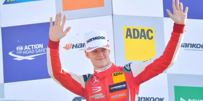 Der deutsche Rennfahrer Mick Schumacher winkt bei einer Siegerehrung. Der deutsche Rennfahrer Mick Schumacher winkt bei einer Siegerehrung.