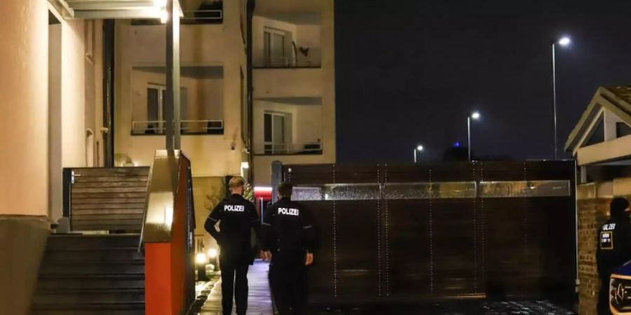 Polizisten stehen während einer Razzia wegen des Besitzes und der Verbreitung von Kinderpornographie an einem Wohnhaus in Herdecke. Foto: Alex Talash/dpa