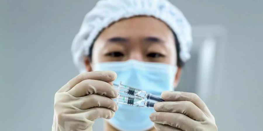 In Peking wird die Verpackungsqualität von inaktivierten Corona-Impfstoffprodukten geprüft. Foto: Zhang Yuwei/XinHua/dpa
