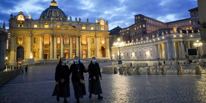 Nonnen mit Mund-Nasen-Bedeckungen gehen über den leeren Petersplatz. Das Coronavirus verändert das Weltbild in Italien. Coronavirus - Italien