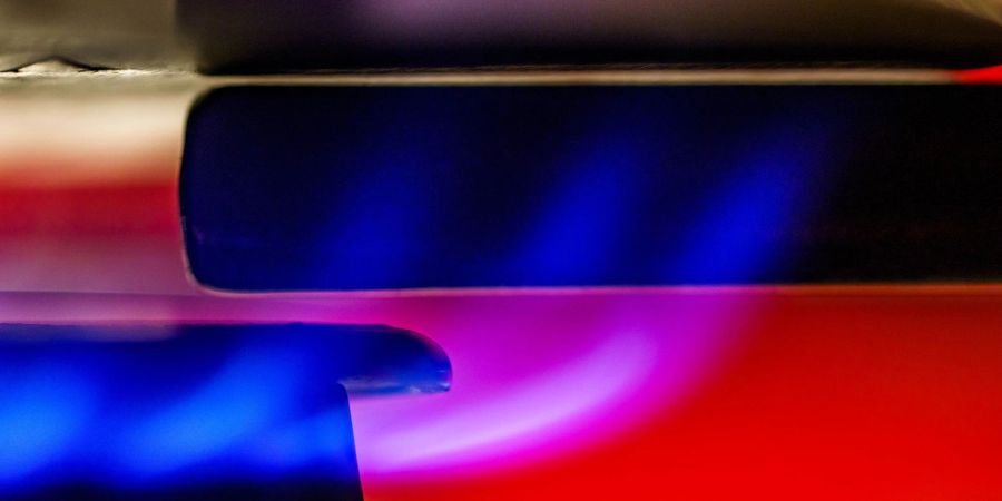 Eine Gasflamme erhitzt Wasser in einem Kochtopf.