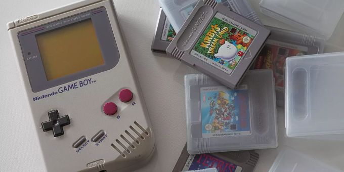Ein Game Boy liegt neben mehreren Spielen. Happy Birthday Game Boy