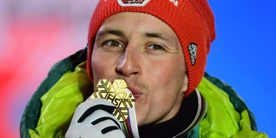 Bei der Siegerehrung küsst Eric Frenzel seine Goldmedaille. Foto: Hendrik Schmidt