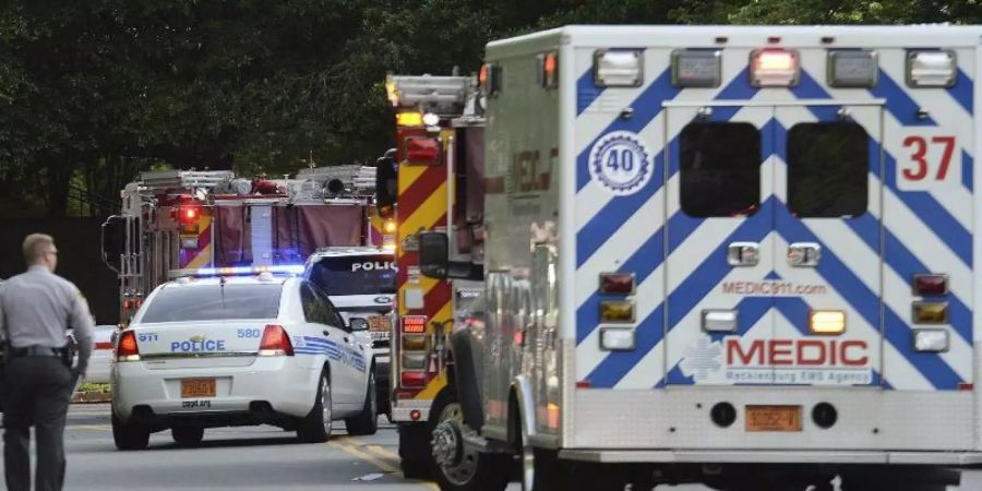 Polizei- und Rettungsfahrzeuge stehen auf einer Strasse vor einer Universität. Nach Schüssen an einer Universität im US-Bundesstaat North Carolina sind zwei Menschen gestorben. Foto: John Simmons/The Charlotte Observer/AP