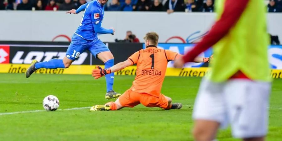 Hoffenheims Ishak Belfodil (l) überspielt Leverkusens Torwart Lukas Hradecky und bereitet damit das Tor zum 4:1 durch Andrej Kramaric (nicht im Bild) vor. Foto: Uwe Anspach/dpa