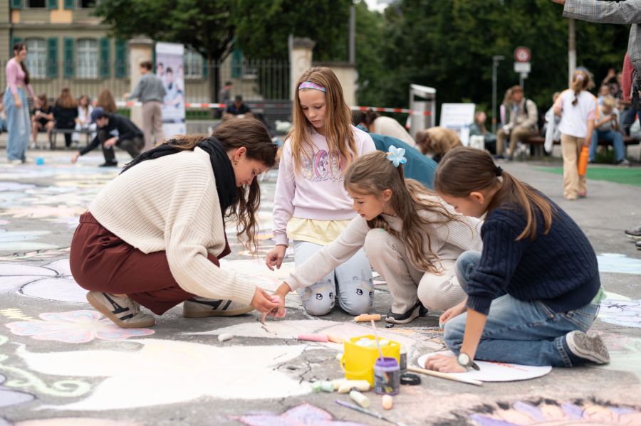 Gemeinsam kreativ – Kinder und Jugendliche lassen mit Kreidefarben die Vision eines blühenden Gartens aufleben.