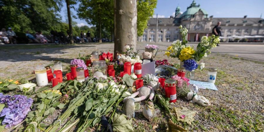 Blumen, Kerzen und handgeschriebene Trauerbekundungen stehen an einem Baum im Kurpark Bad Oeynhausen. Jetzt steht die Anklage.