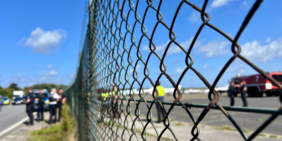 Am Flughafen Sylt sind Polizisten schnell zur Stelle, nachdem Klima-Aktivisten der Letzten Generation ein Loch in den Zaun geschnitten haben und auf das Gelände gelangt sind.