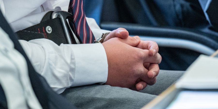 Der Beschuldigte sitzt mit Handschellen im Verhandlungssaal des Landgerichts. Foto: Armin Weigel/dpa