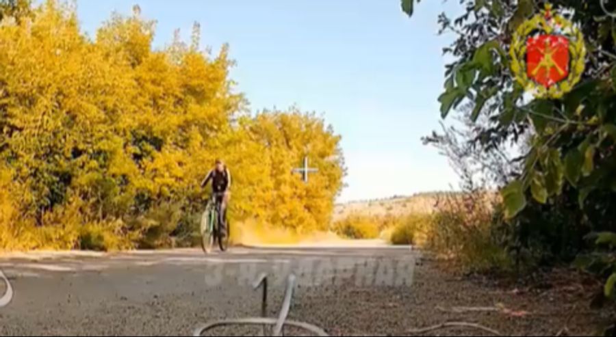 Ein Velofahrer fährt auf einer Schotter-Strasse, zeigt ein Video, das zuerst die russische Armee geteilt hat.