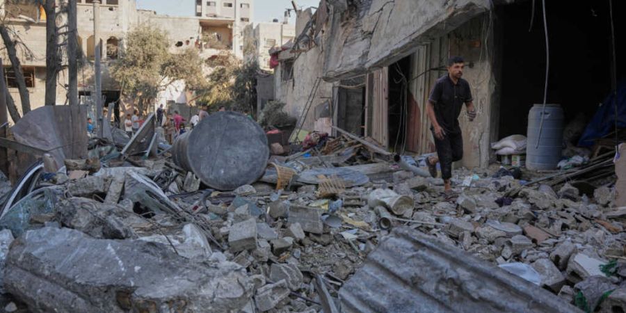Palästinenser gehen im Gazastreifen nach einem israelischen Luftangriff durch die Trümmer. Foto: Abdel Kareem Hana/AP/dpa/Archivbild