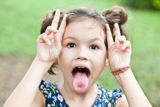 Oft steckt ein einfacher Grund dahinter, warum Kinder lügen. Mädchen streckt zunge raus