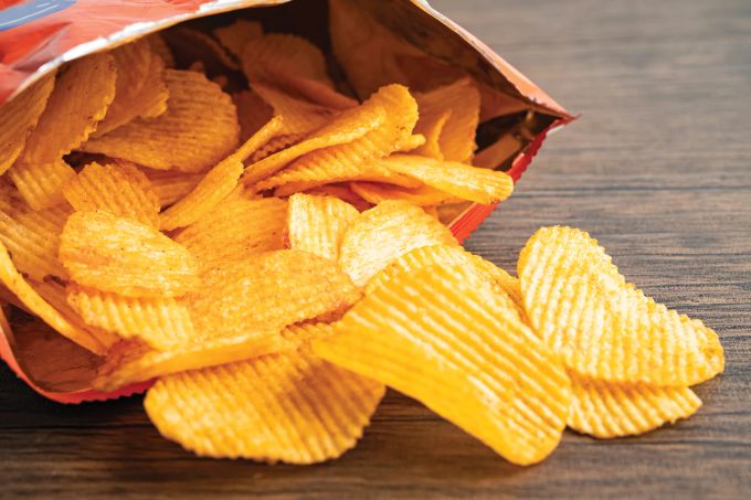 Herkömmliche Kartoffelchips bestehen zu etwa 50 Prozent aus Kohlenhydraten, die im Körper zu Glukose abgebaut werden. kartoffelchips in tüte
