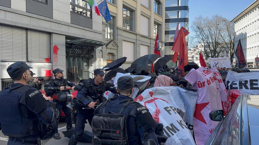 Demonstranten bewerfen Gebäude mit Farbe.