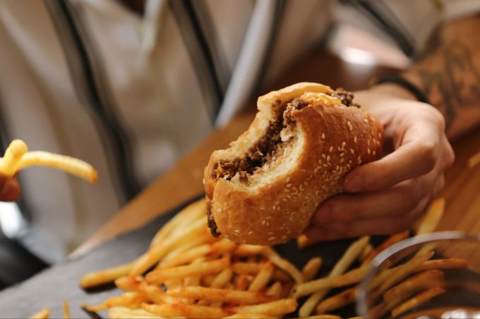 Stress und Erschöpfung sind ein häufiger Grund, sich etwas zu bestellen oder unterwegs Fast Food zu essen. Burger, Pommes