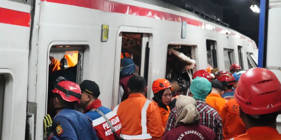 Rettungskräfte suchen nach einer Zugkollision in einem Bahnhof in Bekasi, Indonesien, nach Opfern. Foto: Ahmad Ibrahim/AP/dpa