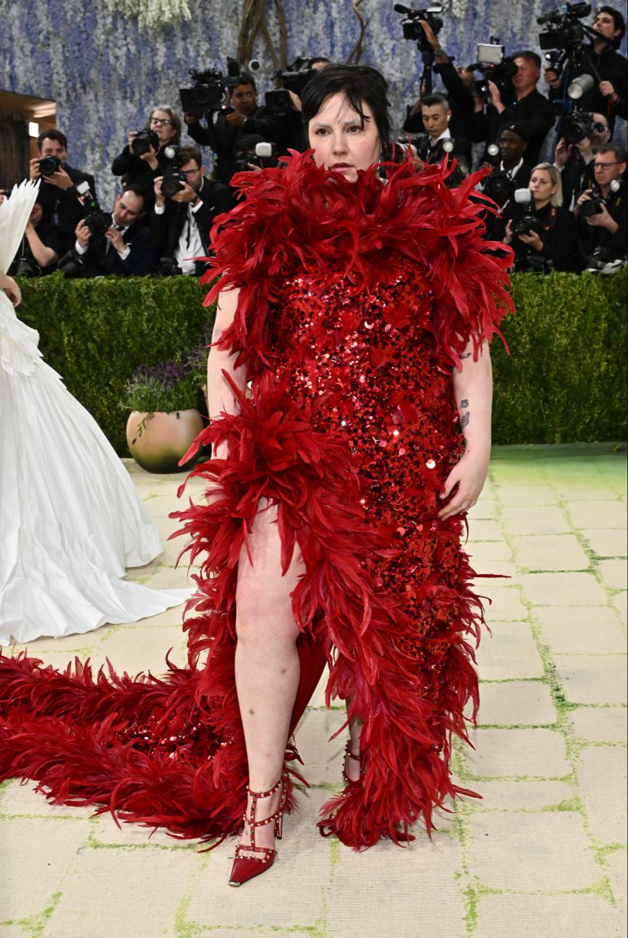 Lena Dunham setzte an der Met Gala auf Rot, Federn und Pailletten. Der Look fiel deutlich aus dem Rahmen.